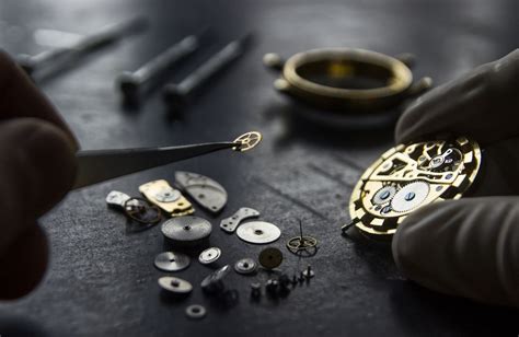 Gros plan sur un artisan sertisseur travaillant avec précision sur une montre Cartier.