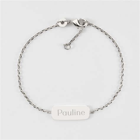 Gros plan sur un bracelet avec une médaille gravée du prénom d'un enfant et de la mention