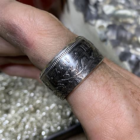 Photographie d'une bague artisanale en argent fabriquée à partir d'une pièce de monnaie ancienne.