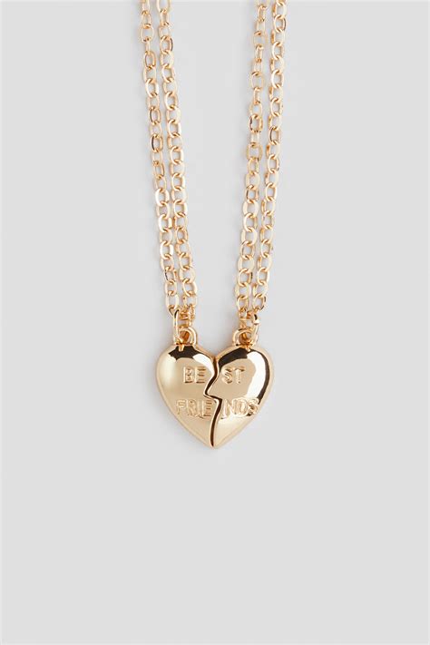 Exemples de pendentifs personnalisés pour enfants : un cœur gravé, une étoile, et un pendentif avec initiale.