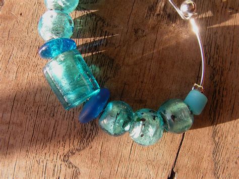 Photo détaillée d'un bracelet en papier résiné avec des perles bleues et argentées