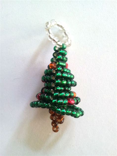 Collection de miniatures de Noël réalisées en perles de rocaille, incluant un Père Noël et des angelots.