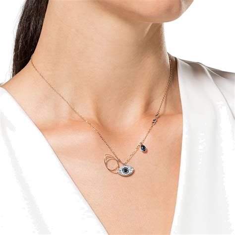 Gros plan sur le pendentif Œil du Mal Swarovski Duo, mettant en valeur les cristaux et le métal doré rose.