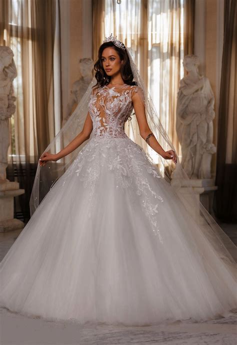 Une robe de mariée ornée de cristaux Swarovski, de style princesse, avec des détails en tulle et broderies.