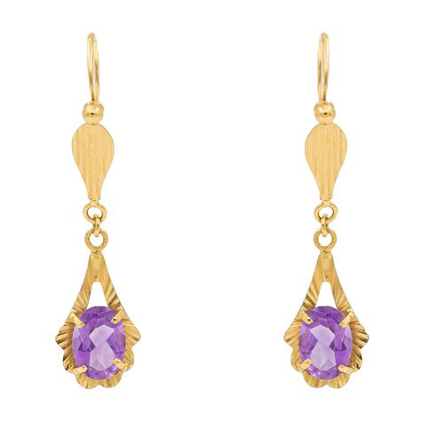 Photo des boucles d'oreilles dormeuses barre en or avec améthystes taille princesse
