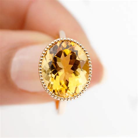 Photographie d'un écrin élégant contenant une bague en vermeil et citrine, avec une chamoisine.