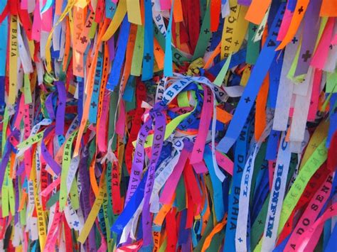 Photographie d'un bracelet Senhor do Bonfim coloré noué à un poignet.