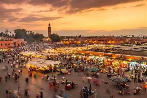 Vue panoramique colorée et animée des souks de Marrakech, avec des étals débordant de marchandises et des passants