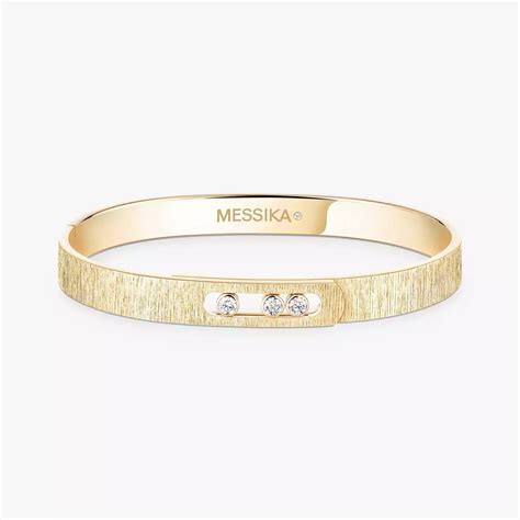 Gros plan sur un bracelet en or marocain finement ciselé, mettant en évidence les motifs traditionnels et l'éclat du métal