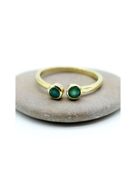 Gros plan sur une bague personnalisée à deux pierres de naissance, montrant la qualité du sertissage des pierres et la finition de l'anneau.