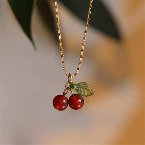 Pendentif collier en forme de cerises rouges sur une chaîne dorée