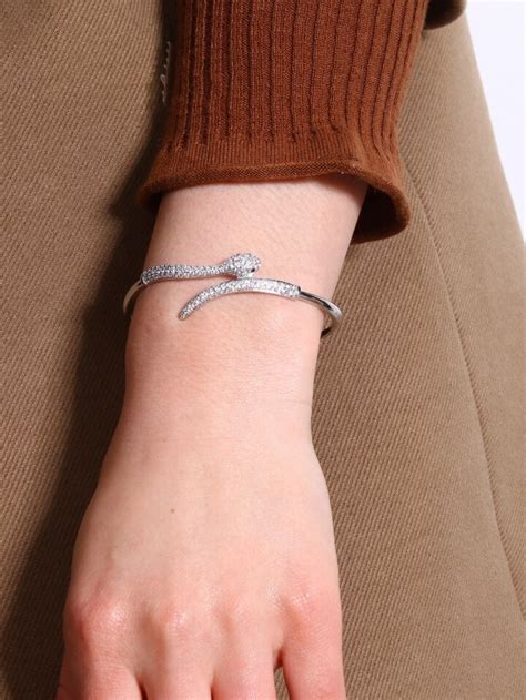Schéma détaillé du bracelet serpent avec cristaux Swarovski, mettant en évidence le serpent, les Zirconia, la Crystal Pearl et le cordon rouge.