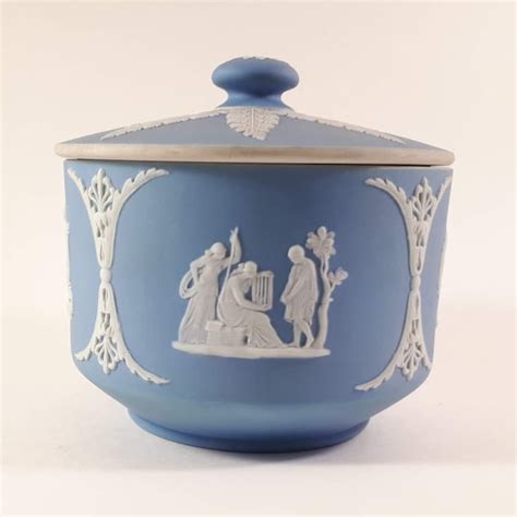 Image illustrant la technique du jasperware de Wedgwood avec des bas-reliefs blancs sur fond coloré