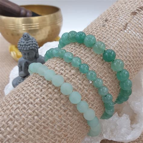 Une sélection de bijoux en aventurine verte, incluant des colliers, bracelets et bagues, mettant en valeur la couleur et la texture naturelles de la pierre.