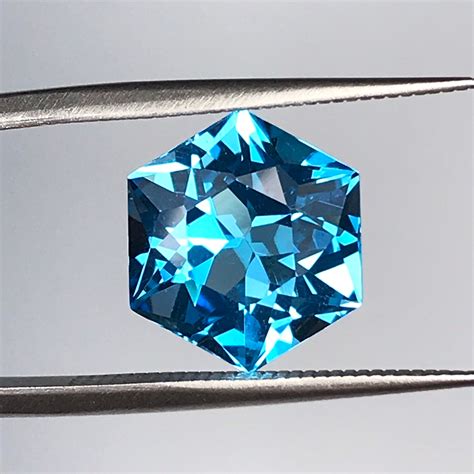 Photographie macro d'une topaze bleue suisse aux multiples facettes, mettant en valeur sa couleur intense et sa brillance.