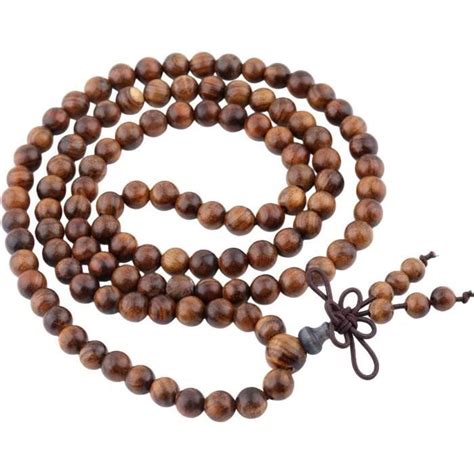 Photographie macro d'une perle de Mala avec un nœud artisanal entre deux perles.