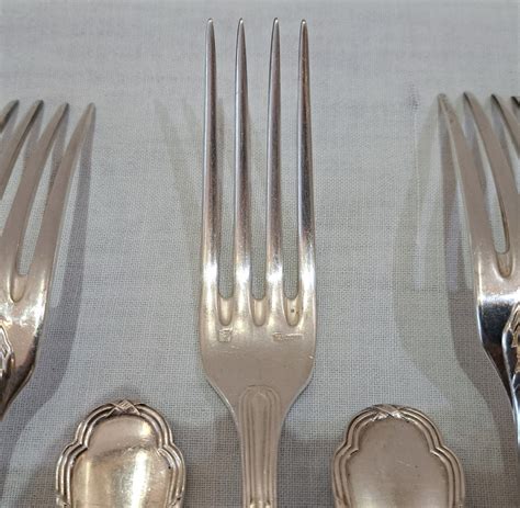 Photographie d'un service de table élégant en argent de la marque Ercuis