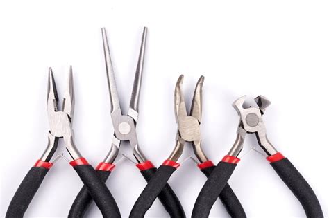 Ensemble d'outils de bijouterie : différentes pinces, coupe-fil, et accessoires de finition.