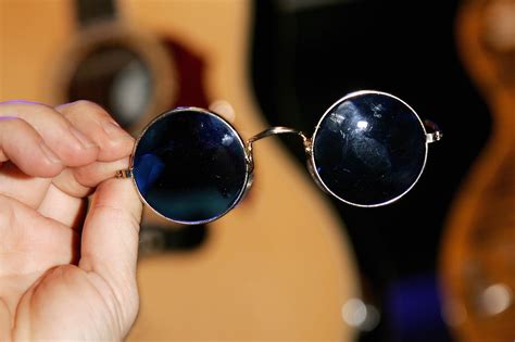 Photographie d'archives montrant John Lennon portant ses lunettes rondes emblématiques.