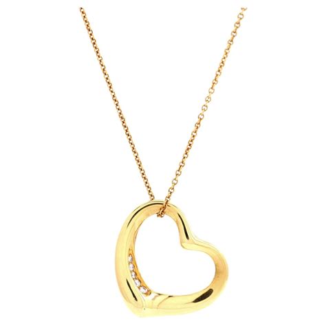 Pendentif cœur ouvert révélant un espace pour insérer une photo, entouré de motifs délicats