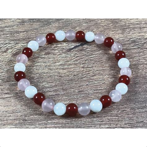 Photographie d'un bracelet en pierres semi-précieuses, incluant de la cornaline, du quartz rose et de la pierre de lune.