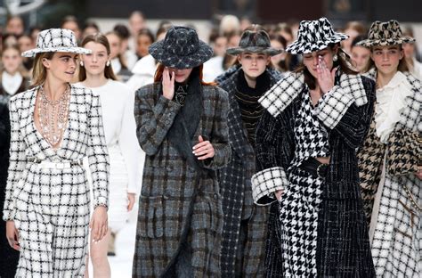 Karl Lagerfeld lors d'un défilé Chanel avec des mannequins portant ses créations emblématiques