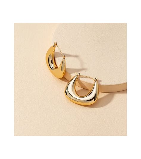 Gros plan sur un chiffon doux nettoyant une boucle d'oreille dorée.