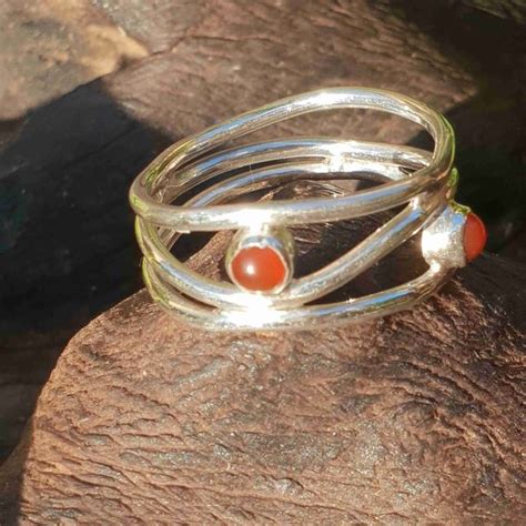 Une bague en argent ornée d'une pierre naturelle aux couleurs vives.