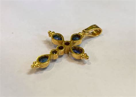 Schéma détaillé du pendentif fleur avec saphirs et diamant, indiquant les dimensions et la disposition des pierres.