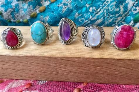 Photographie d'une bague avec une pierre centrale manquante et une autre avec une pierre de remplacement.