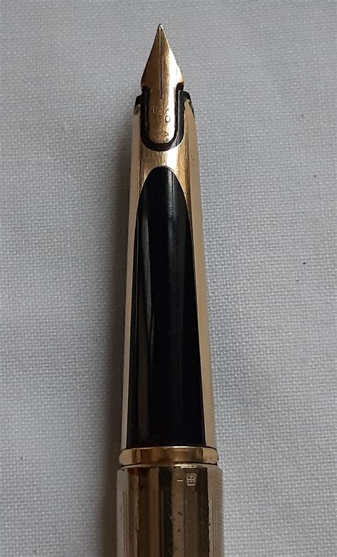 Gros plan sur une plume en or 18 carats d'un stylo Waterman, montrant les gravures et la pointe.