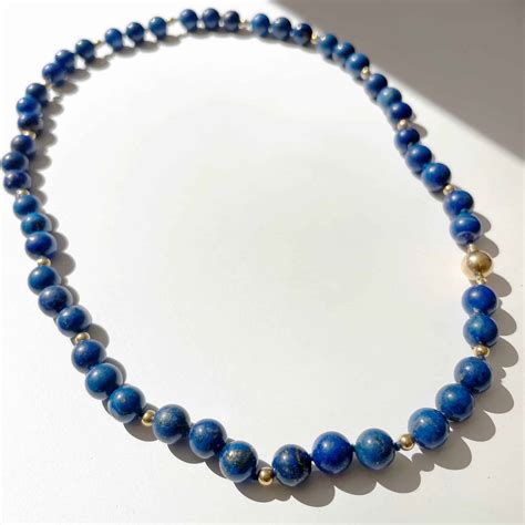 Détail d'un collier funéraire en or avec incrustations de lapis-lazuli et d'agate, dont le fermoir représente Horus.
