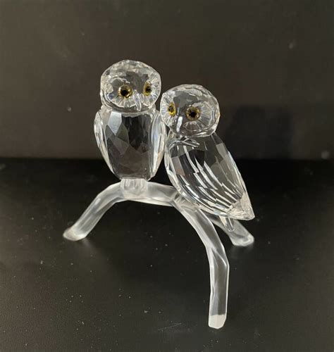 Figurine Swarovski en forme de couple de hiboux amoureux, ornée de cristaux incolores.