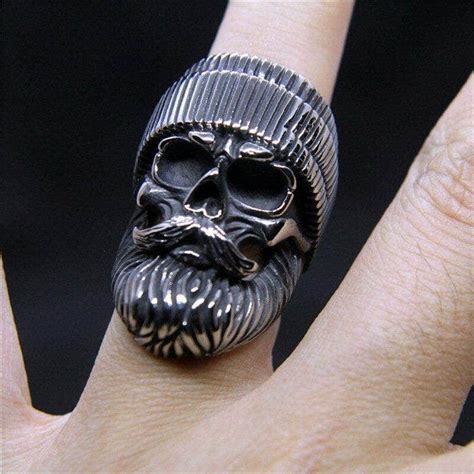 Illustration d'un ensemble de bijoux de motard : chaîne, bracelet clouté, bague tête de mort